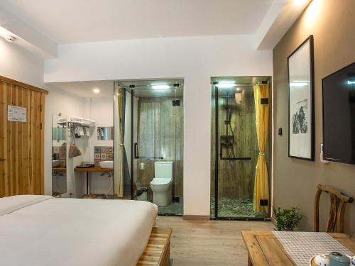 a bedroom with a bed and a shower and a toilet at Cloudy Warm Hotel - Huangshan Scenic Area Transfer Center Branch in Huangshan City