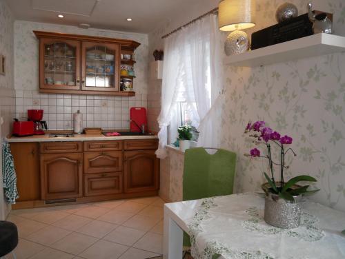 eine Küche mit einem Tisch, einem Waschbecken, einem Tisch und einem Tisch in der Unterkunft Bungalow Rarek "20 Gehmin vom Ostseestrand" in Bansin