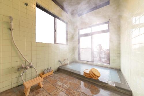 een badkamer met een bad, een toilet en een raam bij HAKUDAKU no YUYA in Beppu