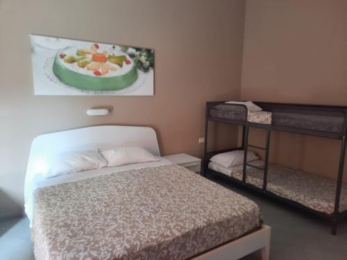 a bedroom with a bed and a cake on the wall at Residence Le Isole in Marsala