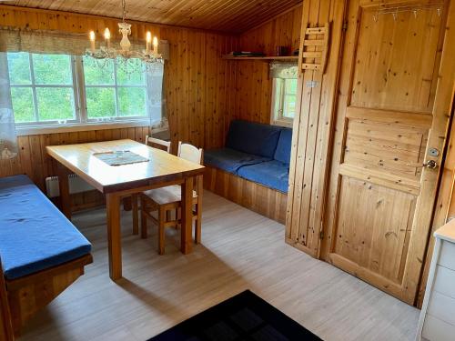 ein Zimmer mit einem Tisch und einem Sofa in einer Hütte in der Unterkunft Fjällhalsen Cottages in Fjällhalsen