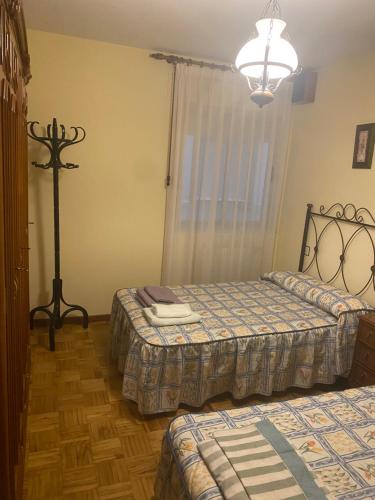 a bedroom with two beds and a lamp at Apartamento Couto in Ribadeo