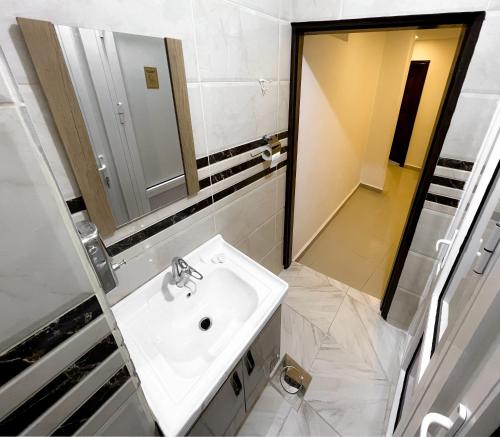 a white bathroom with a sink and a mirror at Petra Cloud 1977 in Wadi Musa