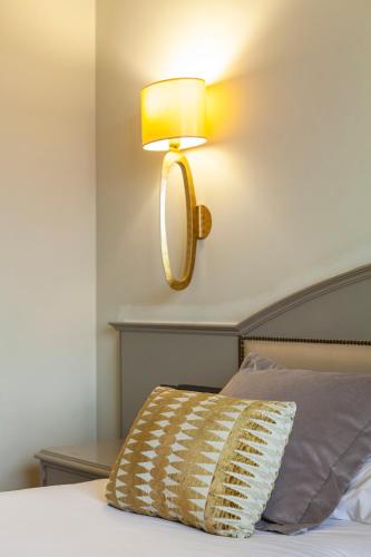 a lamp on the wall above a bed with a pillow at Hotel Bahía in Santander