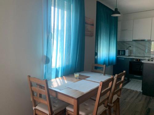uma mesa de jantar com duas cadeiras e uma cortina azul em Verona Apartment em Sandanski