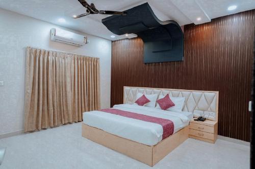 - une chambre avec un grand lit et un éclairage dans l'établissement Bajaj's Karwan Inn, à Jagdalpur