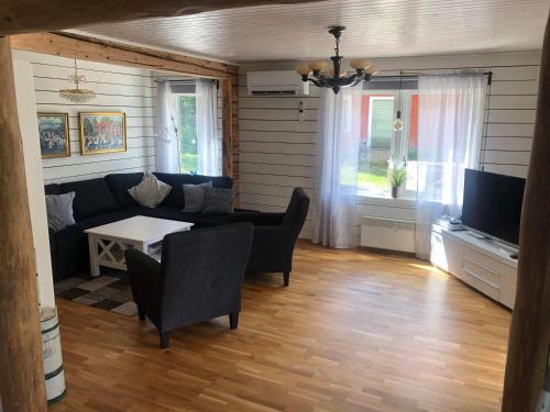 a living room with a couch and a table at Stor Familjegård i bra läge in Finström
