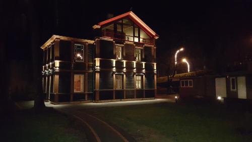 a large wooden house at night with lights on it at Exquisite 1930's Historical House in Jūrmala