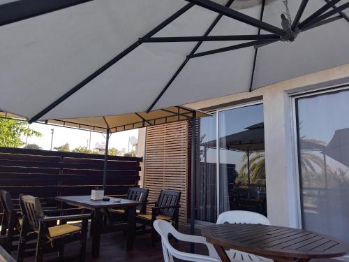 a patio with tables and chairs and a large window at ARIADNIS 3 BEDs apt in Pomos