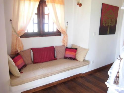 a couch sitting in a room with a window at Lanka Beach Boutique Bungalows & Grand Villa in Tangalle