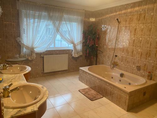 a bathroom with two sinks and a tub and a window at Apartamento Couto in Ribadeo