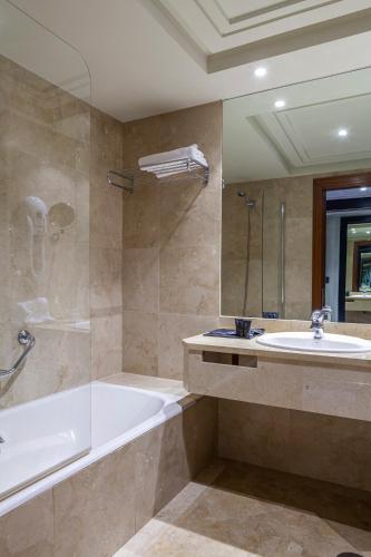a bathroom with a tub and a sink at Hotel Bahía in Santander