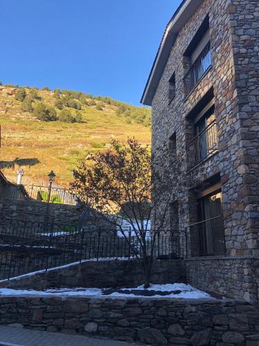 a stone building with a tree in front of it at Casa Nova Regi in Soldeu