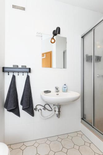 a white bathroom with a sink and a shower at Ferienwohnung Nordseebutze in Esens