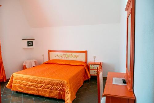 a bedroom with a bed with an orange bedspread at La Villetta Food & Drink Rooms for Rent - No Reception - in LʼAquila