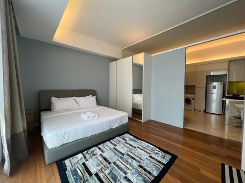 a bedroom with a white bed and a kitchen at The Signature Serviced Suites Kuala Lumpur in Kuala Lumpur