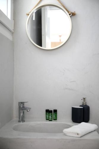 a bathroom with a sink and a mirror at Sea Nymphs Suites in Agia Anna Naxos