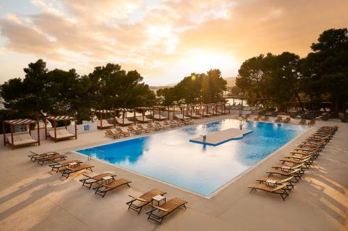 una grande piscina con sedie a sdraio e un gruppo di pellicani di Ville Imperial Vodice a Vodice