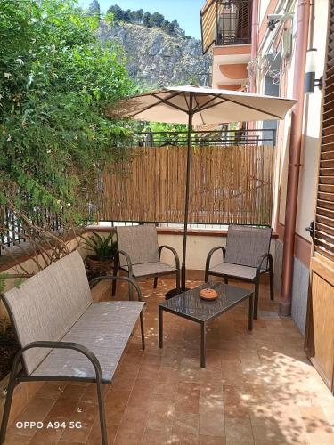 a patio with two chairs and a table and an umbrella at La casetta della Letizia in Mondello