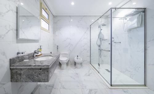 a bathroom with a shower and a sink and a toilet at Radisson Hotel Riyadh Airport in Riyadh