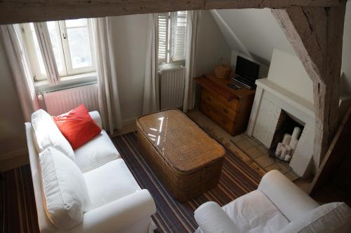 a living room with two white couches and a fireplace at Studio Rempart in Brussels