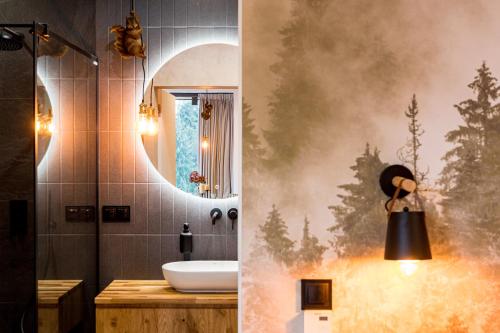 W łazience znajduje się umywalka i lustro. w obiekcie Biały Las w mieście Białka Tatrzanska
