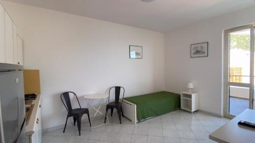 a room with two chairs and a table with a green bed at CannetoMare in Canneto