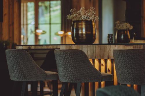 a group of chairs sitting at a table with a vase at CHALET VILLAGE ZAGLGUT Wellness & Views with Summer Card Included in Kaprun