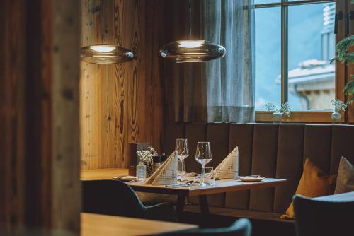 a dining room with a table with wine glasses at CHALET VILLAGE ZAGLGUT Wellness & Views with Summer Card Included in Kaprun