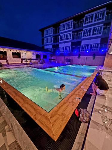 a group of people in a swimming pool at night at Grand Parazo Hotel Suvarnbhumi Airport in Bang Hia