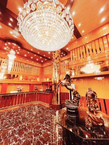a large chandelier in a lobby with a marble floor at Grand Parazo Hotel Suvarnbhumi Airport in Bang Hia