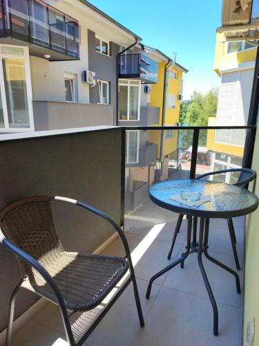 a glass table and a chair on a balcony at Spa Koncept-Apartmani in Veliko Gradište