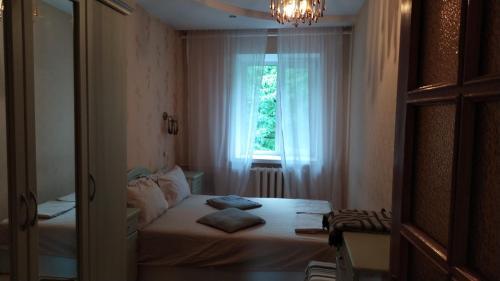 um pequeno quarto com uma cama e uma janela em Three Bedroom Stepana Bandery Street em Rivne