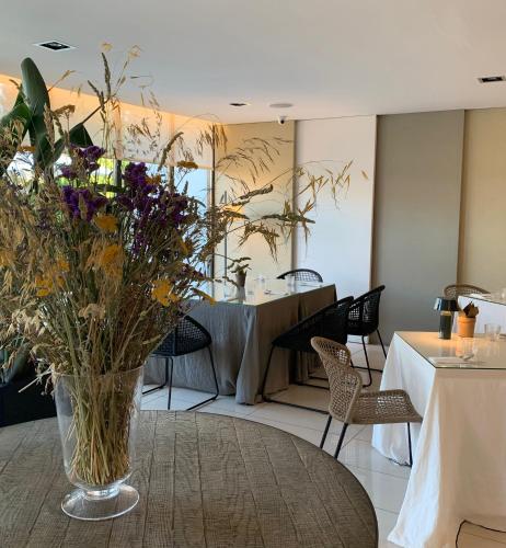 a room with a table and a vase of flowers on a table at Hotel Eden Park by Brava Hoteles in Riudellots de la Selva