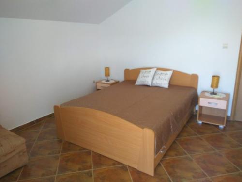 a bedroom with a bed with two night stands and two tables at Apartment Villa Radovic II in Risan