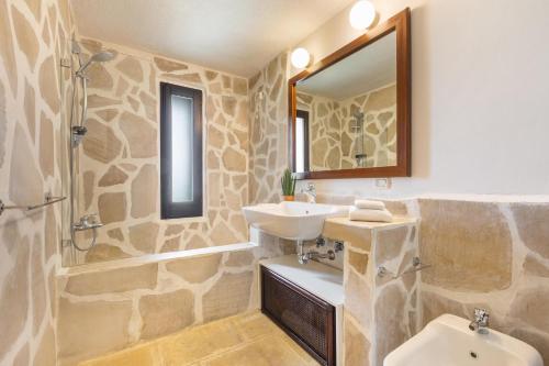 ein Badezimmer mit Waschbecken, Toilette und Spiegel in der Unterkunft Villa La Pajara in Santa Maria di Leuca