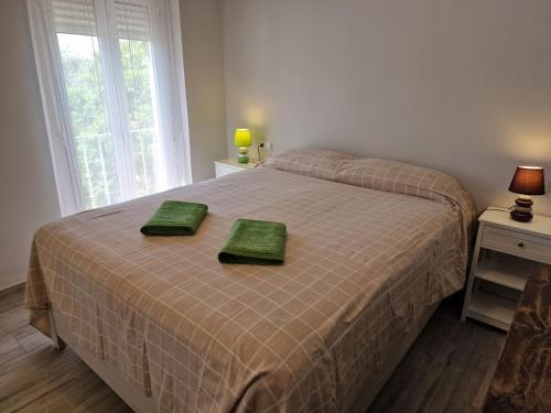 een slaapkamer met een bed met twee groene handdoeken erop bij DS Ribera, con aparcamiento opcional in Córdoba