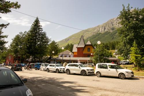 a row of cars parked on the side of a street at La Villetta Food & Drink Rooms for Rent - No Reception - in LʼAquila