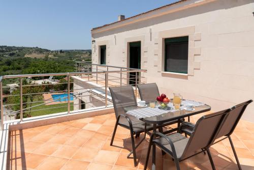 a patio with a table and chairs on a balcony at Villa Elia by PosarelliVillas in Vryses
