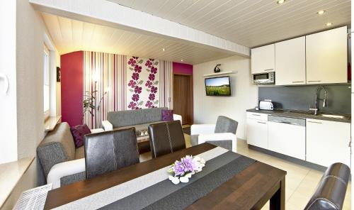 a kitchen and a living room with a dining table at Kühne's 4 Sterne Komfort-Apartments in Braunlage