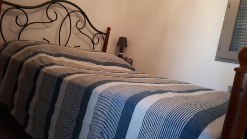 - un lit avec une couverture rayée bleue et blanche dans l'établissement la playa, à Gruissan