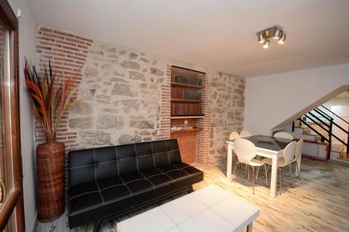 a living room with a black leather couch and a table at Casa Ramon y Cajal Alcañiz in Alcañiz