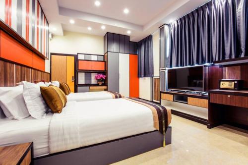 a bedroom with two beds and a flat screen tv at Grand Parazo Hotel Suvarnbhumi Airport in Bang Hia
