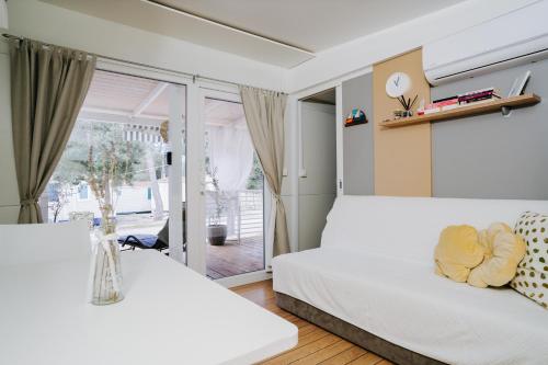 a bedroom with a white bed and a window at Mobile home RENE in Biograd na Moru