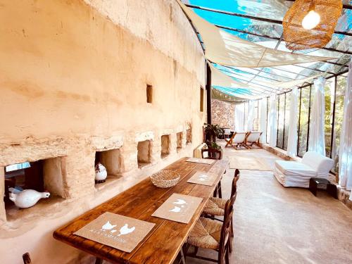 d'une salle à manger avec une table en bois et quelques fenêtres. dans l'établissement Très Belle rotonde déco Bohème, tennis, parking, à Nîmes