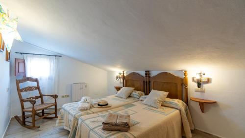 um quarto com 2 camas e uma cadeira em Villa Fuente Luz Frigiliana by Ruralidays em Frigiliana
