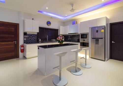a kitchen with a counter and stools in it at Sunset Paradise Villa in Haad Pleayleam
