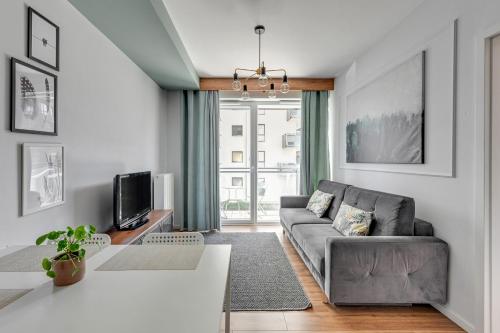 a living room with a couch and a tv at Grand Apartments - Bastion Wałowa Jager - Apartament Gdańsk in Gdańsk