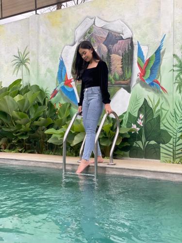a woman is standing on a rail in the water at Ra Inn Kemang in Jakarta