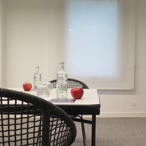 two apples sitting on a table with two chairs at Hotel Eden Park by Brava Hoteles in Riudellots de la Selva